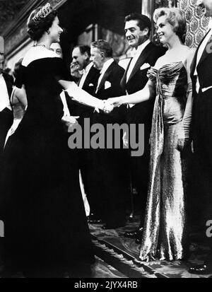 Datei-Foto vom 29/10/1956 von Marilyn Monroe, das sich mit Königin Elizabeth II. Bei der Royal Film Performance von 'The Battle of the River Plate' 1956 im Empire Theatre, Leicester Square, die Hände schüttelte. Wie Buckingham Palace mitteilte, starb die Königin heute Nachmittag friedlich in Balmoral. Ausgabedatum: Donnerstag, 8. September 2022. Stockfoto