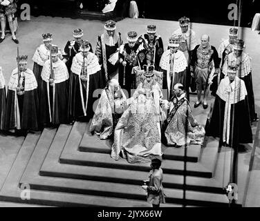 Datei-Foto vom 02/06/1953 von Königin Elizabeth II. Auf dem Thron, als Bischöfe ihr während ihrer Krönung in Westminster Abbey, London, huldigen. Wie Buckingham Palace mitteilte, starb die Königin heute Nachmittag friedlich in Balmoral. Ausgabedatum: Donnerstag, 8. September 2022. Stockfoto