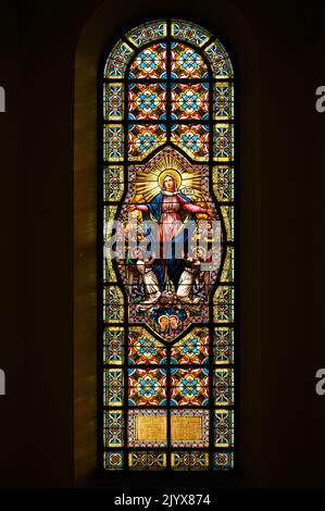 Buntglasfenster mit Darstellung der Himmelfahrt der Jungfrau Maria. Blumental Kirche in Bratislava, Slowakei. Stockfoto