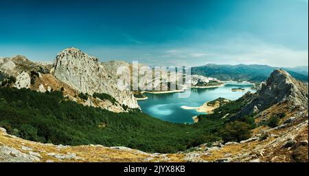 Panoramablick auf den stausee Riaño vom gipfel des gilbo, Panorama mit einem Wald im Vordergrund und einem Sumpf umgeben von felsigen Bergen, Turquo Stockfoto
