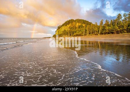 Ein Regenbogen am Himmel über Tow Hill und Agate Beach, in Haisa Gwaii, British Columbia Stockfoto