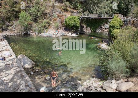 Guijo de Sta Barbara - 25.. August 2022: Besucher genießen das natürliche Schwimmbad La Maquina, Guijo de Santa Barbara, Spanien. Kristallklares Wasser vor Ort Stockfoto