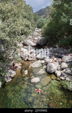 Guijo de Sta Barbara - 25.. August 2022: Besucher des Naturpools La Maquina, Guijo de Santa Barbara, Spanien. Kristallklares Wasser vor Ort Stockfoto