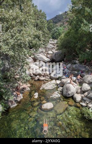 Guijo de Sta Barbara - 25.. August 2022: Besucher des Naturpools La Maquina, Guijo de Santa Barbara, Spanien. Kristallklares Wasser vor Ort Stockfoto