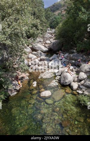 Guijo de Sta Barbara - 25.. August 2022: Besucher des Naturpools La Maquina, Guijo de Santa Barbara, Spanien. Kristallklares Wasser vor Ort Stockfoto