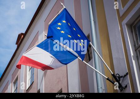 EU- und französische Flaggen hängen an einem Gebäude zusammen. Frankreich und der Europäischen Union. Stockfoto