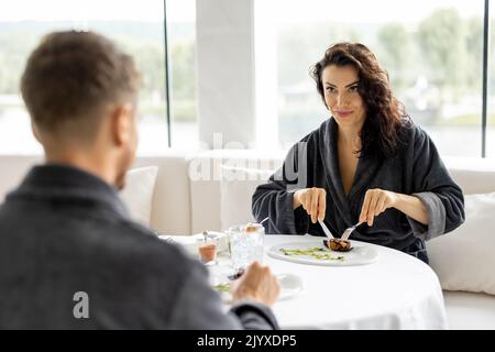 Pärchen essen im Restaurant im Spa Resort wunderschöne Gerichte Stockfoto