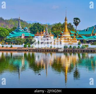 Die historischen Tempel Wat Chong Kham und Wat Chong Klang sowie ihre Stupas und Pyathen spiegeln sich auf den Gewässern des Nong Kham Lake, Mae Hong Son, Thaila Stockfoto