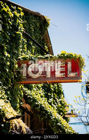 Ein rustikales Motelschild mit Efeu bedeckt außerhalb der Innenstadt von San Luis Obispo, Kalifornien an einem Sommertag. Stockfoto