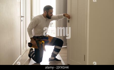 Portrait Junge männliche Tischler reparieren Türschloss Stockfoto