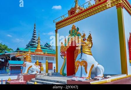 Die weiß-goldenen Statuen der Chinthe (Singha) Löwen am Eingang zum Ucosot des Wat Chong Kham Tempels, Mae Hong Son, Thailand Stockfoto