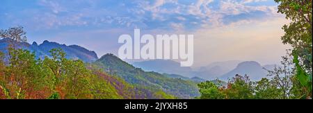 Die verschwommene Silhouette der thailändischen Highlands, bedeckt mit üppigen Wäldern in der Abenddämmerung, Thailand Stockfoto