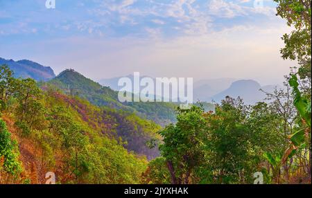 Die Silhouetten des malerischen Thai Highlands, bedeckt mit tiefen Wäldern bei dem weichen Licht des trüben Sonnenuntergangs, Mae Hong Son, Thailand Stockfoto