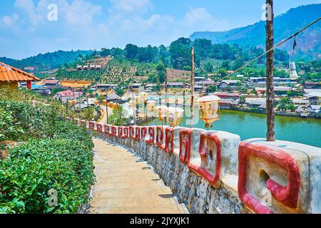 Spazieren Sie durch die Festungsmauer mit hängenden chinesischen Laternen und beobachten Sie das Yunnan Teeldorf rund um den Mae Sa-Nga See, Ban Rak Thai, Thailand Stockfoto