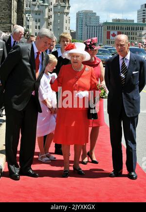 Datei-Foto vom 1/7/2010 von Königin Elizabeth II, in den roten und weißen Farben der kanadischen Flagge, mit Stephen Harper, dem Premierminister von Kanada (links), und dem Herzog von Edinburgh, nach der Ankunft, um an den Feierlichkeiten zum Canada Day teilzunehmen, in Ottawa. Elizabeth II. War berühmt für ihre Liebe zu Blockfarben und passenden Hüten und ihre Mode wurde zu einem legendären Teil ihrer Rolle als Monarch. Die Königin wurde einst als „Powerdressing in Extremis“ beschrieben, weil sie mit lebhaften Schattierungen sich von der Menge abheben ließ, während ihre Hüte sie leicht erkennen ließen, aber klein genug waren, so dass ihr Gesicht gegenüber war Stockfoto