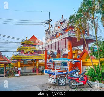 PAI, THAILAND - 6. MAI 2019: Traditionelles Holztor des Wat Pa Kham Tempels, verziert mit geschnitzten Metallornamenten und massiven Säulen, am 6. Mai in Pai Stockfoto