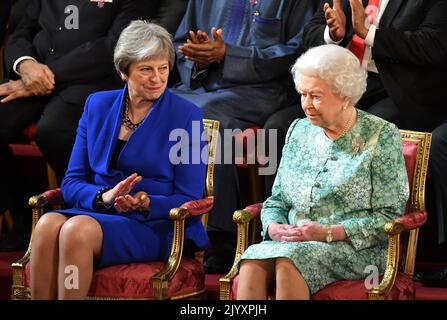 Datei-Foto vom 19/4/2018 von Premierministerin Theresa May mit Königin Elizabeth II. Bei der offiziellen Eröffnung des Commonwealth-Treffen der Regierungschefs im Ballsaal des Buckingham Palace in London. Die Königin sah während ihrer Regierungszeit 13 Premierminister kommen und gehen - mit Boris Johnson als 14.. Ausgabedatum: Donnerstag, 8. September 2022. Stockfoto