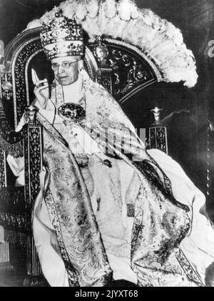 Zeichen der Genesung – Papst Pius XII. Segnet offenbar wegen seiner schwersten Krankheit die vatikanischen Massen, die sich heute zu Ehren seines 16.. Jahrestages seiner Krönung versammelten. Mehr als 5.000 Pilger packten zwei Vorzimmer der Sixtinischen Kapelle, um das Oberhaupt der römisch-katholischen Kirche zu jubeln, als er auf seinem tragbaren Thron hingetragen wurde. Es war das erste Mal seit drei Jahren, dass der heute 79-jährige Papst gut genug war, um an einer Gedenkfeier teilzunehmen. 12. März 1955. (Foto von AP Wirephoto) Stockfoto