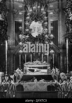 Seligsprechung von Papst Pius X. Photo Show: Vor dem päpstlichen Altar in St. Peter ist während der Seligsprechung am 3. Juni ein Bronze- und Kristallgehäuse mit dem erhaltenen Leichnam von Papst Pius X. ausgestellt. Über dem Hauptaltar ist ein Gemälde des Seligsprechenden zu sehen. Im Vordergrund sind Schweizer Garden zu sehen. Papst Pius X., der erste katholische Papst, der seit 279 Jahren seliggesprochen wurde, wurde am 3. Juni angefleht. Bei Gott Fürsprache halten, um einen wahren und dauerhaften Platz für die Welt zu erhalten. Die Lesung des Briefs zur Seligsprechung fand früher in der Petersbasilika statt, aber die Verehrung des von Papst Pius XII. Seligsprechenden fand in St. Stockfoto