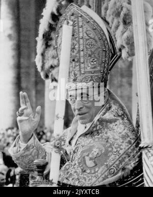 Päpstlicher Segen – Papst Pius XII., der auf seinem tragbaren Thron sitzt, wird auf dem Petersplatz am Vatikan-Samstag von Menschenmengen getragen und bekennt seinen Segen auf einer auf 500.000 geschätzt Menge während der Zeremonie, in der Giuseppe Sarto - Papst Pius X. - als neuester Heiliger der römisch-katholischen Kirche heilig gesprochen wurde. Es war die erste Heiligsprechung für einen Papst seit 242 Jahren. 31.Mai 1954. (Foto von AP Wirephoto) Stockfoto