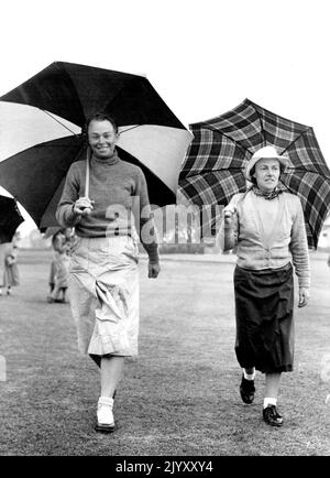 Das nasse Wetter heiratete am Donnerstag den zweiten Spieltag bei den Australian Women’s Jubilee Amateur Golf Championships in Kooyonga. Hier gehen Miss J. Percy (Q), links, und Miss B. Kernot (Vic.) zum 17. Green. Beide waren in der 16 zu qualifizieren, und Miss Percy 77 war die beste Runde für den Tag. 1. September 1951. Stockfoto