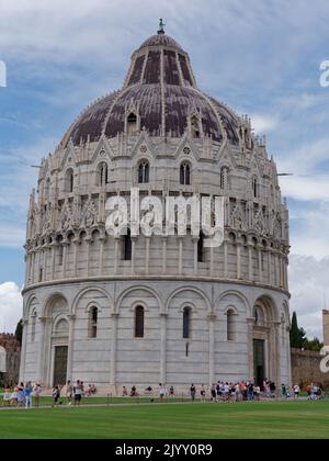 Touristen versammeln sich um das Baptisterium auf dem Platz der Wunder, Pisa, Toskana, Italien. Stockfoto