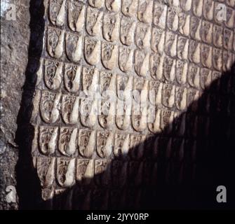 Die Longmen Grotten (Pinyin) oder Longmen Höhlen, chinesische buddhistische Schreine in der Provinz Henan, China. Die Bilder, von denen viele einst gemalt wurden, wurden als Felsreliefs außerhalb und in künstlichen Höhlen geschnitzt, die von den Kalksteinfelsen der Berge Xiangshan und Longmenshan ausgegraben wurden. In den 2.345 Höhlen befinden sich bis zu 100.000 Statuen. Aus der Nördlichen Wei-Dynastie im Jahre 493 n. Chr. Stockfoto