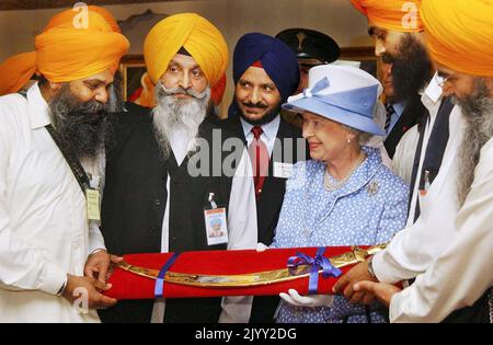 Datei-Foto vom 1/8/2002 von Königin Elizabeth II., die am Ende eines Besuchs im Sikh Gurdhwara Tempel in Leicester ein zeremonielles Schwert (Tulwar) als Geschenk erhielt. Das Schwert ist auch Sikhs bekannt, die für ihre Kampfeigenschaften bekannt sind, als „Kirpan“ oder „Siri-Sahib“. Ausgabedatum: Donnerstag, 8. September 2022. Stockfoto