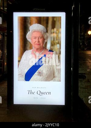 London, Großbritannien. 08. September 2022. Ein Neonschild an einer Bushaltestelle auf der Chiswick High Road zeigt ein Foto von Queen Elizabeth II mit den Daten 1926-2022. Die britische Königin Elizabeth II. Ist tot. Sie starb am Donnerstag im Alter von 96 Jahren auf ihrem Landsitz Balmoral Castle in Schottland. Quelle: Gaby Mahlberg/dpa/Alamy Live News Stockfoto