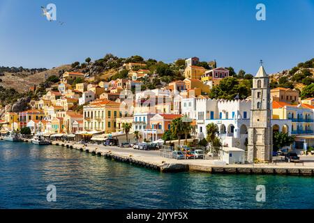 Blick auf die schöne griechische Insel Symi (Simi) mit bunten Häusern und kleinen Booten. Griechenland, Symi Insel, Blick auf die Stadt Symi (bei Rhodos), Stockfoto