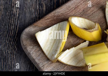 Die gelbe Schale, die nach den Bananen auf dem Brett zurückgelassen wurde, die leere Schale der Bananen, nachdem sie gereinigt wurden, das ist Müll Stockfoto