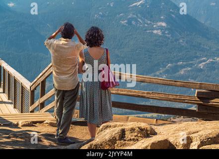 Ein glückliches Paar, das gemeinsam in den Bergen wandert, und Reisende genießen den Aussichtspunkt auf Squamish BC. Pärchen über natürlichen Hintergrund am Berg. Kanada Reisen, t Stockfoto