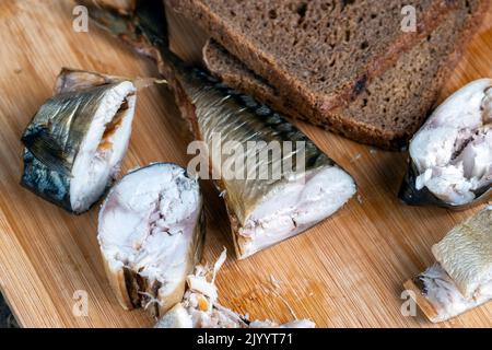 Während des Kochens in Stücke geräucherter Makrele geschnitten, während des Kochens von Fisch geräucherter Makrele Stockfoto