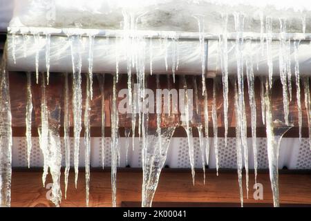 Viele Gefahren-Eiszapfen auf dem Dach und Wasserleitung auf dem Landhaus. Speziell für die Wintersaison Stockfoto