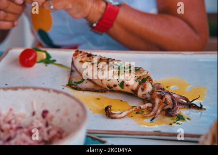 Im Restaurant wird Calamari auf dem Tisch serviert Stockfoto