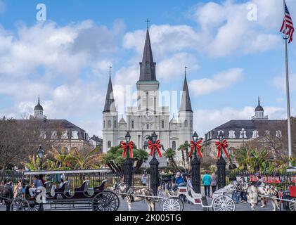 NEW ORLEANS, LA, USA - 30. NOVEMBER 2019: Stadtbild der St. Louis Kathedrale, des Cabildo, der Presbytere, von Maultierwagen gezeichnete Wagen und Weihnachtsdekor Stockfoto