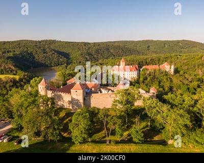 Luftaufnahme der Burg Veveri in der Nähe der Stadt Brünn. Region Südmähren, umgeben vom Fluss Svratka. Sommertag mit blauem Himmel, Sonnenuntergang und sanftem Licht. Stockfoto