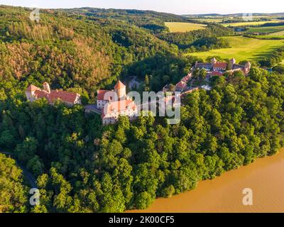 Luftaufnahme der Burg Veveri in der Nähe der Stadt Brünn. Region Südmähren, umgeben vom Fluss Svratka. Sommertag mit blauem Himmel, Sonnenuntergang und sanftem Licht. Stockfoto