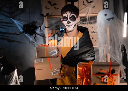 Drop Versand Geschäft Besitzer sprechen tragen weißen Ton Schädel, Home Office professionelle Make-up Vorbereitung Waren für den Versand. Das Konzept der Stockfoto