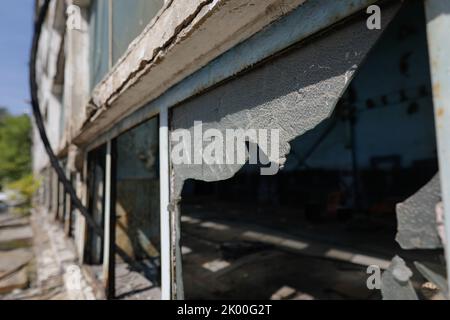 Gebrochene Wände und Fenster in einem verlassenen Industriegebäude. Stockfoto