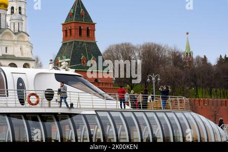 MOSKAU - 21. APRIL 2017: Touristenboot schwimmt auf dem Moskwa-Fluss am Moskauer Kreml, Russland vorbei Stockfoto