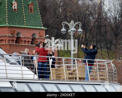 MOSKAU - 21. APRIL 2017: Touristenboot schwimmt auf dem Moskwa-Fluss am Moskauer Kreml, Russland vorbei Stockfoto