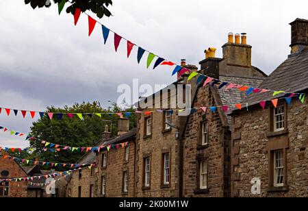 Farbenfrohe, zwischen den Cottages an der Main Street des malerischen Dorfes Winster in Derbyshire aufgereiht. Stockfoto