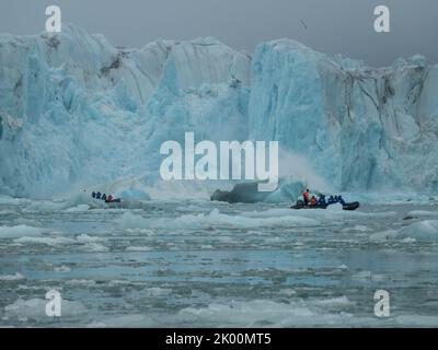 Spektakuläre Aussicht auf den Gletscher mit Zodiac-Booten im Vordergrund. Samarin Breen-Gletscher. Hornsund Fjord, Spitzbergen, Norwegen Stockfoto