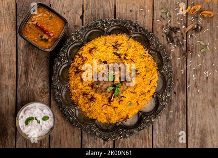 Ein indisches Gericht aus sehr gewürztem Reis und Gewürzen mariniertes Fleisch, das mit eigenen Säften und aromatischen indischen Gewürzen zubereitet und mit Brinjal serviert wird Stockfoto