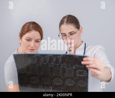 Ärztin erklärt der Patientin die mrt der inneren Organe. Stockfoto