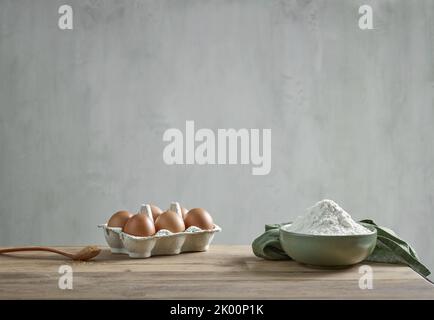 Mehl, Eier und Zucker auf dem hölzernen Küchentisch, Stillleben Stockfoto