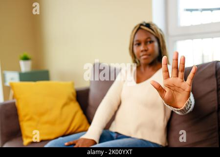 Frau zeigt Handfläche und sagt Nein zu häuslicher Gewalt, Missbrauch und Diskriminierung Stockfoto