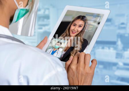 Die Ärztin nutzt digitale Tablets, um Patienten über das Internet medizinische Konsultationen zu ermöglichen, die auf dem neuen normalen Konzept basieren. Stockfoto