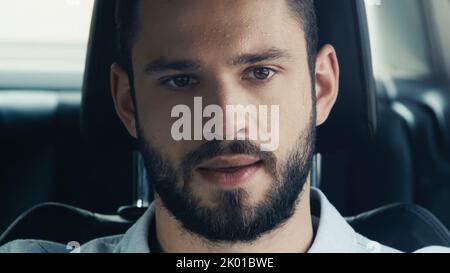 Verschwitzter Mann, der unter Hitze leidet, während er im Sommer mit dem Auto fährt, Stockbild Stockfoto